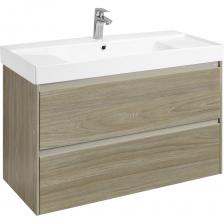 Тумба под раковину Roca Ona Темный Вяз, 2 Ящика, 1000 МмСоздание атмосферы Средиземноморья в вашем доме. Серия Ona от испанской компании Roca подарит вашему интерьеру красоту и практичность, перенеся в мир ярких природных мотивов. Обладая всеми необходимыми качествами качественной сантехнической мебели, тумбы Ona отличаются не только стилем, но и функционалом, предоставляя вам максимум возможностей для организации пространства.Характеристики и преимущества:Материалы изготовления: продукция изготовлена из качественных влагостойких материалов европейского производства, прошедших строгий контроль качества.Удобство эксплуатации: наличие металлической профилированной ручки облегчает открытие ящиков и защищает фасад от повреждений.Организация внутреннего пространства: оба ящика снабжены резиновыми противоскользящими ковриками, верхний ящик дополнительно оборудован системой организованного хранения, помогая поддерживать порядок.Высокая износостойкость: механизм выдвижения Hettich обеспечивает полное выдвижение ящиков и длительное плавное закрытие, протестированное на 60 тыс. циклов использования.Надёжность монтажа: навесы и комплектующие прилагаются в комплекте и выдерживают вес до 100 кг, кроме того, предусмотрена возможность регулирования для точной фиксации.Совместимость с аксессуарами: тумба поставляется совместно с керамической раковиной Ona, выполненной из качественного композита, сочетающего современный внешний вид и долговечность. Тумба под раковину Roca Ona Темный Вяз, 2 Ящика, 1000 МмСоздание атмосферы Средиземноморья в вашем доме. Серия Ona от испанской компании Roca подарит вашему интерьеру красоту и практичность, перенеся в мир ярких природных мотивов. Обладая всеми необходимыми качествами качественной сантехнической мебели, тумбы Ona отличаются не только стилем, но и функционалом, предоставляя вам максимум возможностей для организации пространства.Характеристики и преимущества:Материалы изготовления: продукция изготовлена из качественных влагостойких материалов европейского производства, прошедших строгий контроль качества.Удобство эксплуатации: наличие металлической профилированной ручки облегчает открытие ящиков и защищает фасад от повреждений.Организация внутреннего пространства: оба ящика снабжены резиновыми противоскользящими ковриками, верхний ящик дополнительно оборудован системой организованного хранения, помогая поддерживать порядок.Высокая износостойкость: механизм выдвижения Hettich обеспечивает полное выдвижение ящиков и длительное плавное закрытие, протестированное на 60 тыс. циклов использования.Надёжность монтажа: навесы и комплектующие прилагаются в комплекте и выдерживают вес до 100 кг, кроме того, предусмотрена возможность регулирования для точной фиксации.Совместимость с аксессуарами: тумба поставляется совместно с керамической раковиной Ona, выполненной из качественного композита, сочетающего современный внешний вид и долговечность.