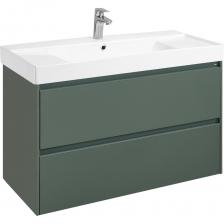 Тумба под раковину Roca Ona Модуль 2 ящика 1000 Зеленый МатовыйПогрузитесь в очарование природы и насладитесь свежестью морских берегов Испании, выбрав коллекцию Roca Ona для своей ванной комнаты. Тумба под раковину в зеленом матовом исполнении – это идеальное сочетание гармонии цветов и функциональности.Ключевые характеристики и преимущества:Качество материалов: Корпус и фасады изготовлены из влагостойкого МДФ, покрыты немецкой матовой пленкой, устойчивой к воде и влажности.Удобство использования: Вся ширина фасада оснащена металлической ручкой-профилем, которая обеспечивает легкий доступ внутрь ящиков. Эта особенность одновременно служит защитой фасада от попадания влаги и повреждений.Организация пространства: Каждый ящик укомплектован противоскользящим ковриком, удерживающим содержимое на месте. Дополнительно верхний ящик оборудован органайзером, помогающим поддерживать идеальный порядок и эстетичное распределение предметов.Высокий ресурс использования: Механизмы ящиков произведены известным брендом Hettich, гарантируя полный и тихий ход выдвижения, тестированные на 60 000 циклов открывания-закрывания. Надежность обеспечена производителями Германии.Практичная установка: Все комплектующие для крепежа идут в комплекте, включая несущие элементы, способные выдержать вес до 100 кг. Возможность точной регулировки креплений позволяет компенсировать отклонения уровня пола и стен, обеспечивая точную горизонтальную установку мебели.